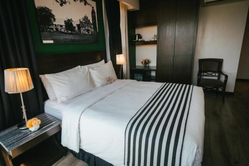 a hotel room with a bed and a table with a lamp at 1898 Hotel Colonia En Las Filipinas in Manila