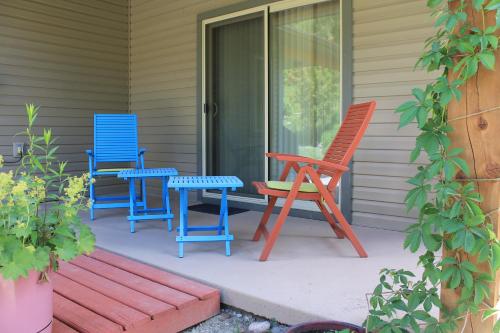 four colorful chairs and a table on a porch at Windborne Bed & Breakfast in Castlegar
