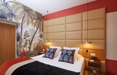 a bedroom with a bed with blue and white pillows at Hotel de Silhouette in Biarritz