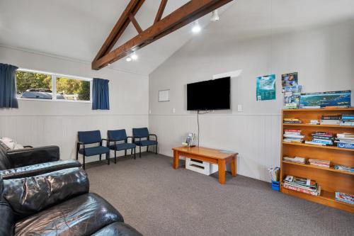 a living room with a couch and a tv and a table at Tasman Holiday Parks Picton in Picton