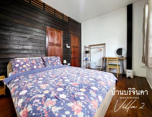 a bedroom with a bed and a wooden wall at V2-Baan Borijinda-Lanna House in The old city of Chiang Mai in Chiang Mai