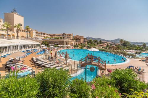 une grande piscine avec chaises et parasols dans l'établissement Hôtel de l'Esterel Pierre & Vacances, à Agay