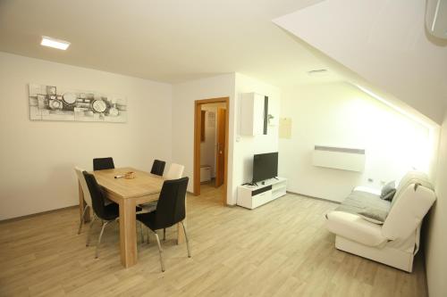 a living room with a table and chairs and a couch at Apartments Vila Leska in Zgornji Leskovec