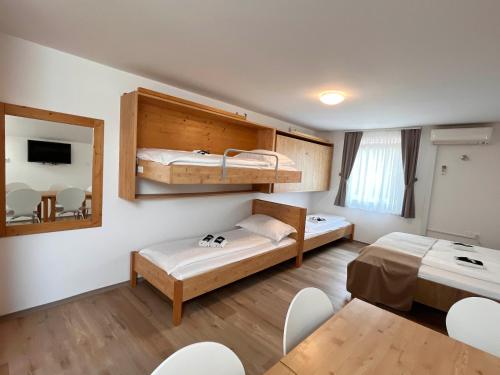 a room with two bunk beds and a table at Apartments Vila Leska in Zgornji Leskovec