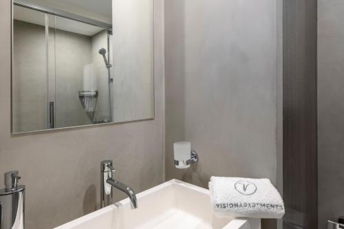 a bathroom with a sink and a mirror at VISIONAPARTMENTS Brandschenkestrasse - contactless check-in in Zürich