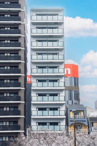 a tall apartment building with trees in front of it at Tanimachi Namba East43 in Osaka