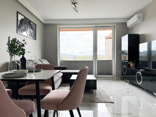 a living room with a table and chairs at Laguna Beskidów Resort - Apartament A74 in Zarzecze