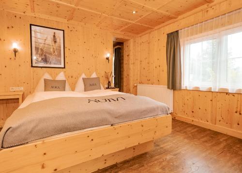 una camera da letto con un letto in una stanza di legno di AURA Bed & Breakfast a Sankt Jakob in Defereggen