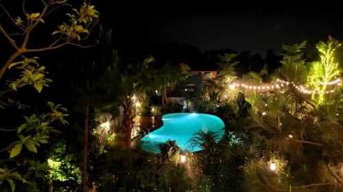 a swimming pool lit up at night with lights at Sóc Sơn - Bird House in Sóc Sơn