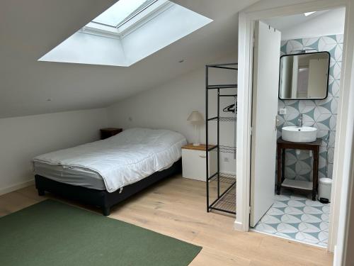 une chambre avec un lit, un lavabo et un miroir dans l'établissement Maison à belle terrasse à Mérignac, à Mérignac