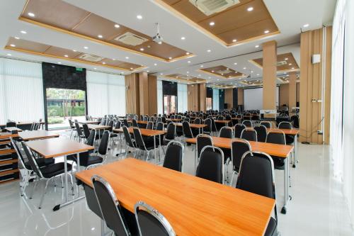 an empty banquet hall with tables and chairs at โรงแรมกัญธิญา การ์เด้น Kanthiya garden hotel in Ban Si Muang Mai