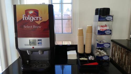 a coffee dispenser with a box of food in a kitchen at Kona Inn Motel Anaheim in Anaheim