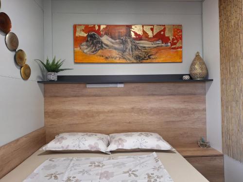 a bedroom with a bed with a wooden headboard at Mobile home Sirena Drage in Drage