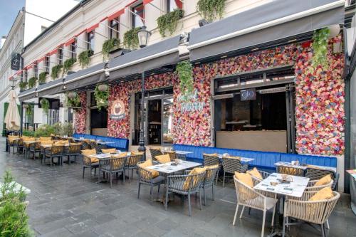 an outdoor patio with tables and chairs in front of a restaurant at Hotel Forty One in Bucharest