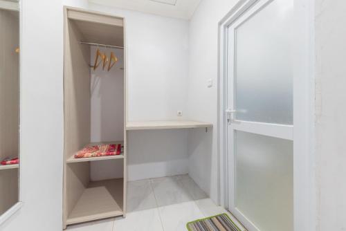 a walk in closet with a glass shower at UrbanView Hotel 3m Syariah in Bandung