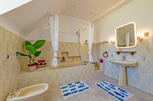a bathroom with a sink and a bath tub at Maison 10 pers 2kms de la plage in Crozon