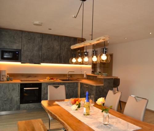 cocina con mesa de madera con sillas y barra en Ferienhof Haslach, en Immenstadt im Allgäu