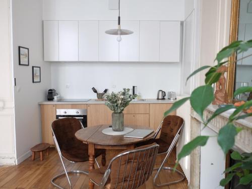 - une cuisine avec une table, des chaises et un ordinateur portable dans l'établissement L'artiste, à Orléans