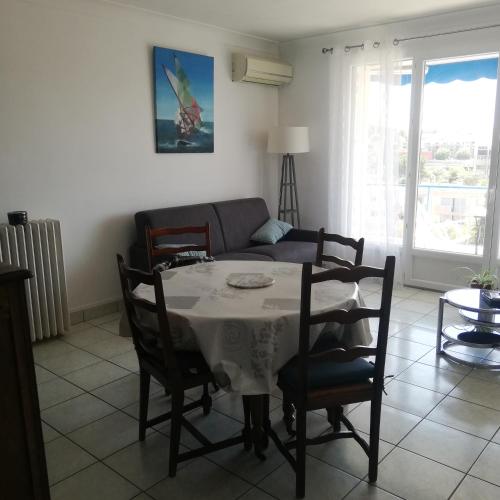 a living room with a table and a couch at Appartement Saint Raphaël in Saint-Raphaël