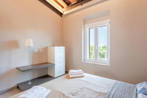 a white bedroom with a bed and a window at Casa Giovanna in Ponte Buggianese