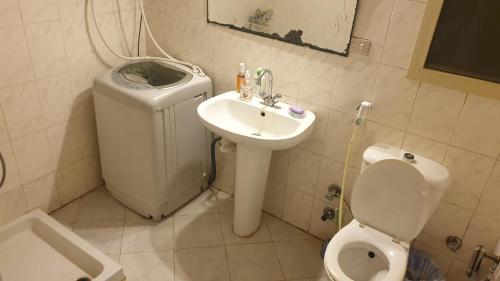 a small bathroom with a toilet and a sink at Summer Doors - Families Only in Dawwār ‘Abd Allāh