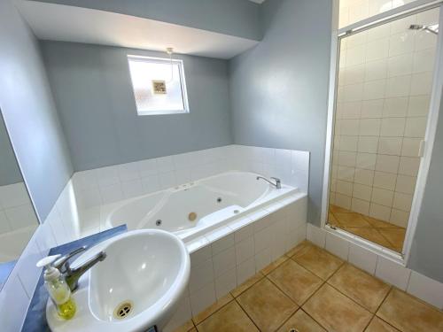 a bathroom with a sink and a bath tub at Osprey Holiday Village Unit 115 in Exmouth