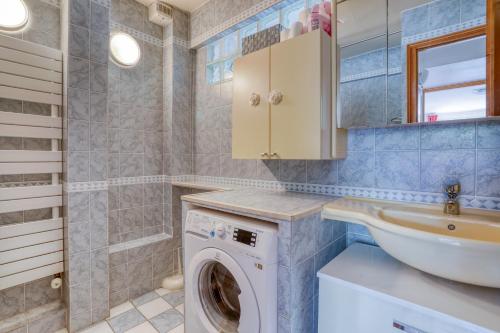 une salle de bain avec une machine à laver et un lavabo dans l'établissement Cette Maison est la Vôtre, à Suresnes