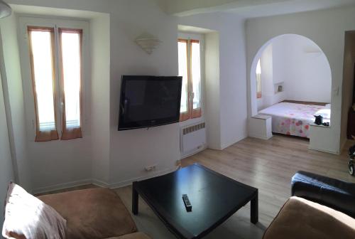 un salon avec un canapé et une télévision sur un mur dans l'établissement Charmant 3 pieces en bord de mer et proche tramway, à Nice