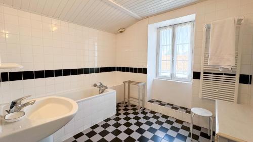 baño con lavabo, bañera y ventana en Charmante location dans le centre de St Martin, en Saint-Martin-de-Ré