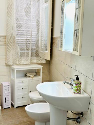 a white bathroom with a sink and a toilet at Billy Home in Villabate