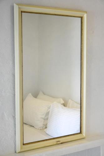 a mirror on top of a shelf with white pillows at Sapsila Patmos Residences in Sapsila
