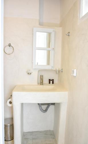 a bathroom with a sink and a mirror at Sapsila Patmos Residences in Sapsila