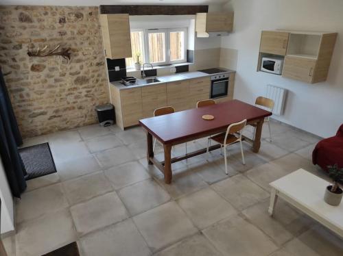 une cuisine avec une table et des chaises dans une pièce dans l'établissement Gite Les'Couves, à Colombiers