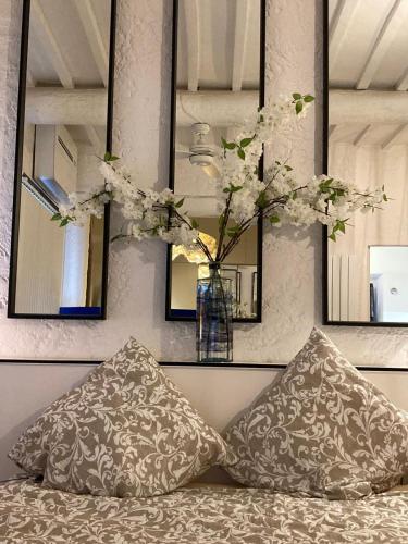 un vase avec des fleurs à l'intérieur posé à côté de deux oreillers dans l'établissement Picasso Walk Cosy charm in heart of Old Town Antibes AC and WiFi, à Antibes