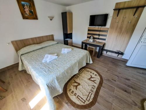 a bedroom with a bed and a table and a television at Casa Livia in 2 Mai