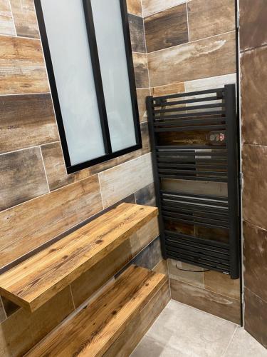 La salle de bains est pourvue d'un banc en bois et d'un miroir. dans l'établissement Appartement cosy, à Vias