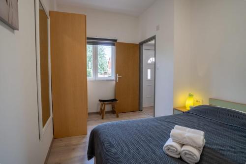 una camera da letto con un letto con due asciugamani sopra di Apartman Mihovil a Gospić