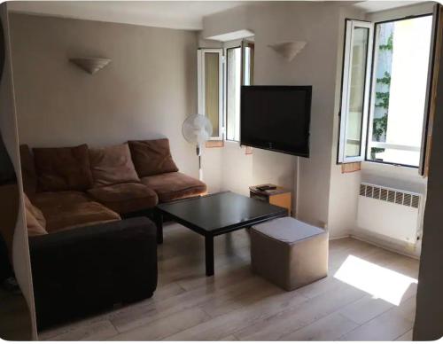 un salon avec un canapé et une table basse dans l'établissement Charmant 3 pieces en bord de mer et proche tramway, à Nice