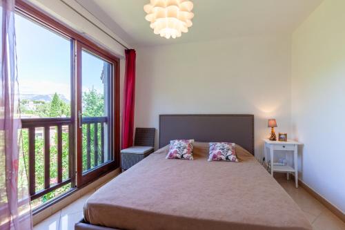 a bedroom with a bed and a large window at Jolie Maison Proche Plage in Toulon