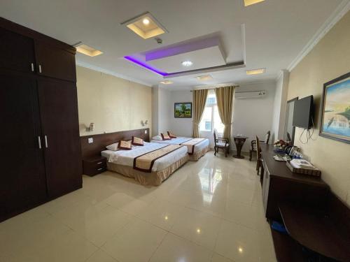 a hotel room with two beds and a tv at Senior Hotel 1 Cần Thơ in Can Tho