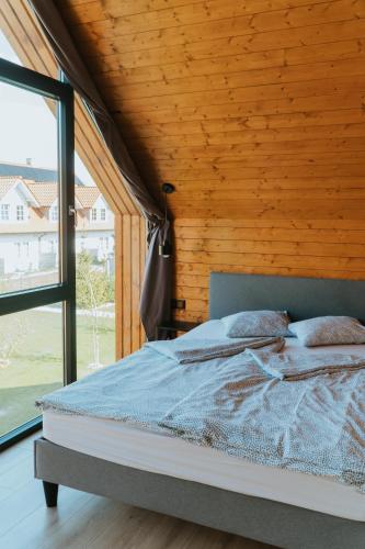 a bed in a room with a large window at Villa Baltica Premium in Niechorze