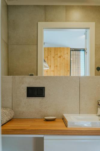 a bathroom with a sink and a mirror at Villa Baltica Premium in Niechorze