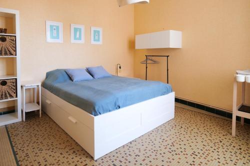 une chambre avec un grand lit avec des draps bleus dans l'établissement Appartement cœur de ville entre port et plage Les Sables 6 personnes, à Les Sables-dʼOlonne