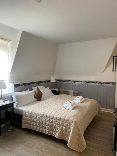 a bedroom with a large bed with white sheets at Hotel Corsten in Heinsberg