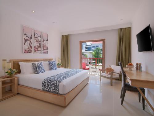 a hotel room with a bed and a desk and a desk at Blu-Zea Resort by Double-Six in Seminyak