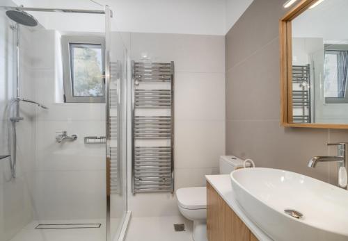 Un baño con lavabo, inodoro y ducha. en La Lucciola apartments, en Lefkada