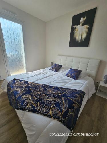 - une chambre avec un grand lit et une couette dans l'établissement Le Petit Hérisson joli logement au rez-de-jardin à Les Herbiers, aux Herbiers