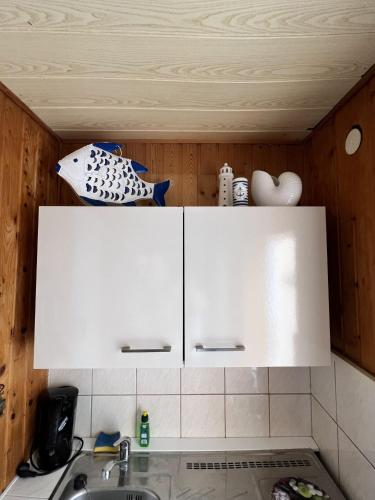 a kitchen with white cabinets and a sink at Zum ehemaligen Kaffeekännchen in Funfseen