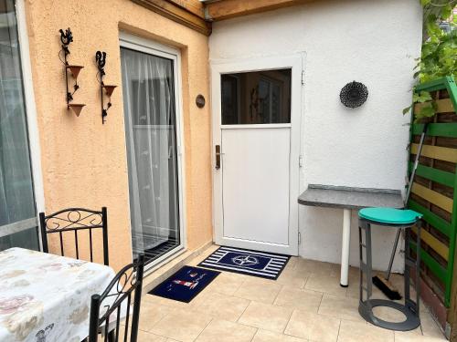 a front door of a house with a table and stool at Zum ehemaligen Kaffeekännchen in Funfseen