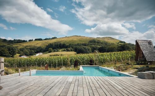 - une piscine sur une terrasse en bois avec une colline dans l'établissement Les Fous du Village, à Saint-Esteben